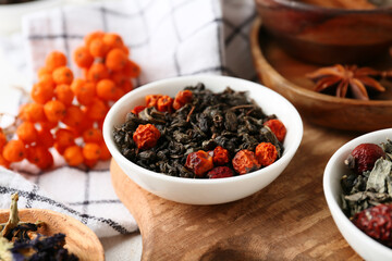 Bowl with dry fruit tea on white grunge table, closeup