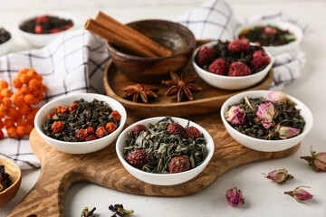 Composition with bowls of different dry fruit tea on white grunge background, closeup