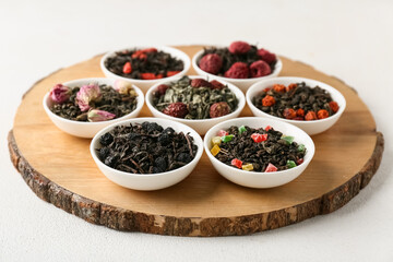 Bowls with different of dry fruit tea on white background, closeup