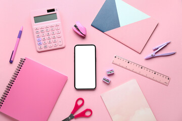 Set of school stationery and mobile phone on pink background