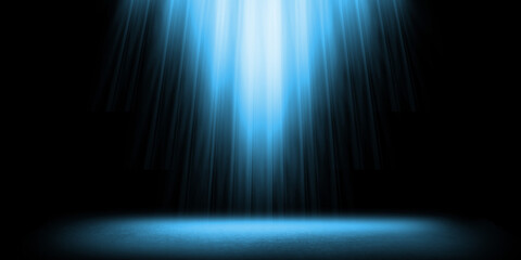 Dark empty stage or room featuring spotlight effect. Intense blue light beams down from above illuminating dark textured stone or concrete floor against black background © sutthichai
