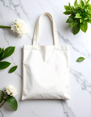 Elegant White Tote Bag Mockup with Floral and Greenery Accents on Marble Surface