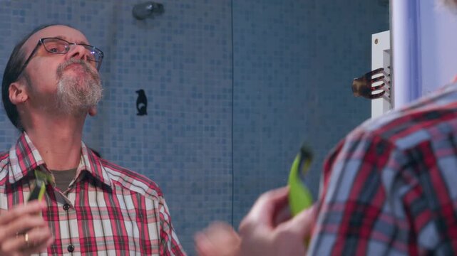 Adult man carefully shaping his goatee style with a cordless beard trimmer