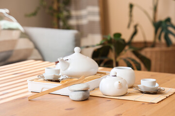 Asian tea set on wooden table in living room, closeup