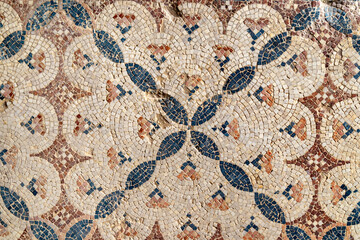 Close view of an ancient floor mosaic with weathered tesserae forming geometric diamond motifs, ideal for archaeology themes, art history contexts, texture uses and Mediterranean heritage 