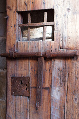 Antique wooden door, typical of a medieval fortification or prison, with rustic details