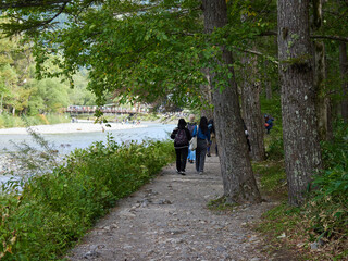 Obraz premium 観光名所上高地の梓川沿岸で散歩する観光客の姿