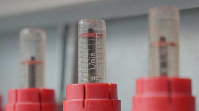 Close-up of flow meters on underfloor heating manifold with visible water level adjustment. Concept of heating regulation, hydraulic balancing and plumbing installation