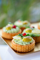 Delicate pastry shells topped with fresh herbs, pickles and berries - perfect for luxury catering, garden parties or gourmet food branding.