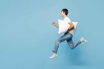 Full body side view calm young man he wear pyjamas jam sleep eye mask rest relax at home jump high...