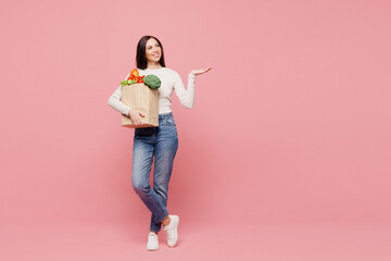 Full body young woman wears white casual clothes hold brown craft bag for takeaway mock up with...