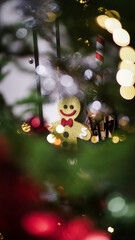 Festive gingerbread cookie in front of a blurred Christmas tree