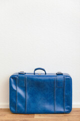 Blue retro leather suitcase on floor in room