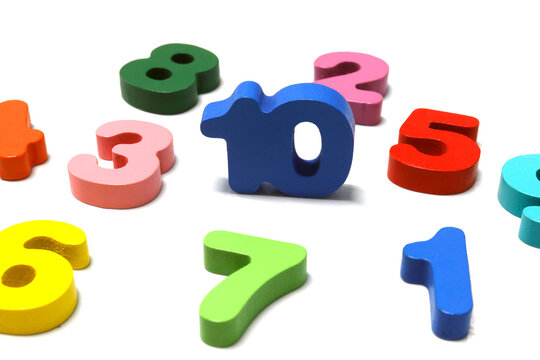 Colorful wooden numbers scattered on a white background. Ideal for education, math learning, kids activities, and teaching materials, close-up - Powered by Adobe
