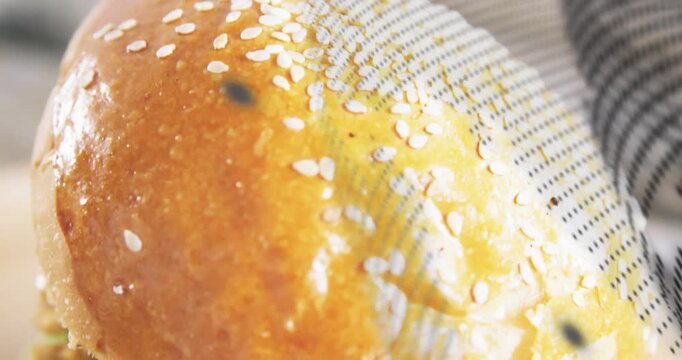 Halftone sweep revealing sesame bun, frame moving down, cheese melting, layers showing for food ad
