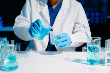 Fototapeta premium Scientist mixing chemical solutions in a modern laboratory, showcasing biotech innovation, chemistry research, diagnostics, and scientific development.