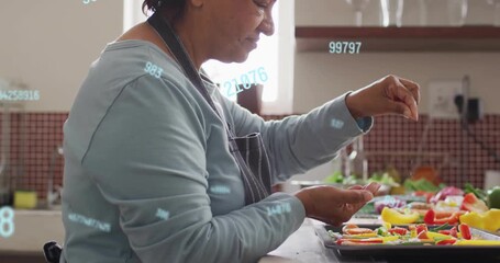 Senior cook starting pinching bits filling color tray as translucent digits overlay hands to bake