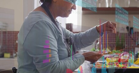 Senior kitchen cook reaching pile, arranging candies on tray for baking, faint bar charts shifting