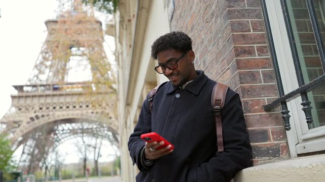 Young man using smartphone near eiffel tower in paris