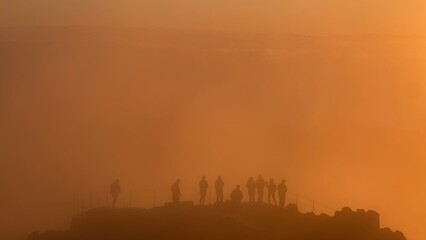Silhouettes of People Watching Sunrise in Golden Mist at Pico do Arieiro, Madeira Island
