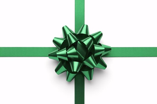 A vibrant emerald green ribbon tied into a decorative bow with four symmetrical loops centered on a crisp white background for gift wrapping - Powered by Adobe