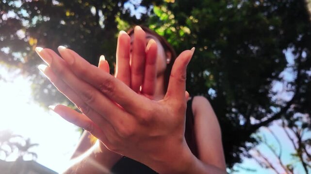 Close-up of hands clapping from low angle, front view, outdoors in nature. Concept of applause, celebration, success, appreciation, support, encouragement, performance, and positive interaction.