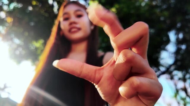 Close-up of hands making a pinch zoom in gesture from low angle, front view, outdoors in nature. Concept of touchscreen interaction, digital zoom, mobile technology and modern digital lifestyle.