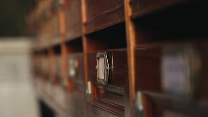 A postman places letters in mailboxes in the entrance of a dilapidated apartment building.