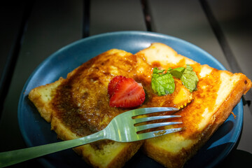 French Toast Slices with Strawberry Mint and Fork on a Dark Plate