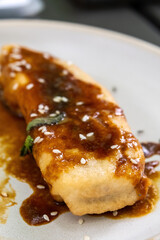 Extreme Close-up of Single Pisang Goreng with Rich Caramel Sauce and Sesame Seeds