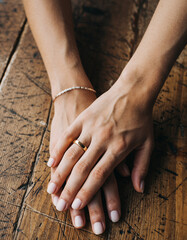 Closeup on hands with a wedding ring on rustic wood. Symbolizing commitment, love, and partnership. Perfect for weddingrelated content, relationships, or intimate moments.