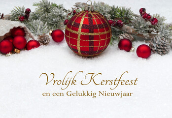 Kerstkaart: Kerstgroeten met kerstboomversieringen en dennentakken in de sneeuw. Vrolijk kerstfeest...