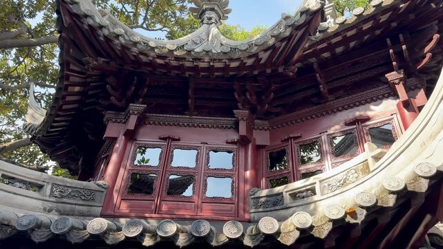 Traditional Yu Garden structure framed by bright sky and lush trees.