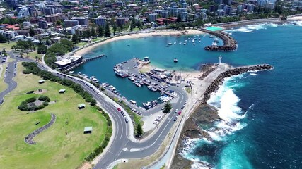 Drone aerial landscape of main road near Wollongong Breakwater Lighthouse bay inlet with Cove Beach along city foreshore waterfront headland and coastline in Illawarra NSW Australia marine tourism