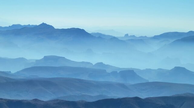 Aerial view of the misty, blue-hued Four Peaks wilderness, with layered mountain ranges fading into the horizon, Apache Junction, Arizona, United States.