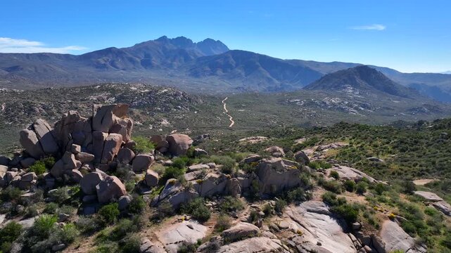 Aerial view of the Four Peaks Wilderness with its rugged mountains, winding trails, and sparse vegetation under a clear sky, Apache Junction, Arizona, United States.