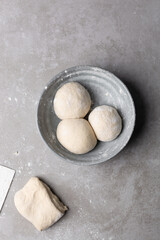 Overhead view of divided chinese scallion pancake dough, top view of chinese pancake dough, process of making cong you bing