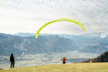 Paragliders taking off from a mountain launch site 