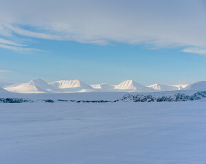 Winter in Svalbard. Glacier front over sea ice
