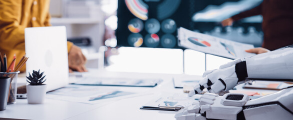 A modern workspace showcasing the integration of robotics in business, featuring digital charts, collaborative efforts, and innovative technology for strategic planning.Noogenesis