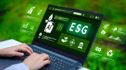 Business person working on laptop with virtual screen displaying ESG performance metrics AI and environmental icons for sustainable corporate management.
