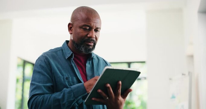 Creative, black man and reading with tablet in office for research, proofreading and update draft. Mature person, digital and editor feedback on article, story submission and publication information