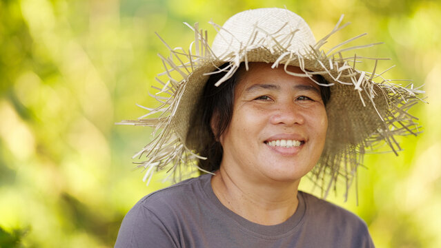 Portrait of asian filipino farmer on farm, smiling, looking at camera, happy, in straw hat, philippines, asia