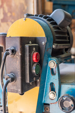 On and off buttons on a light blue woodworking machine