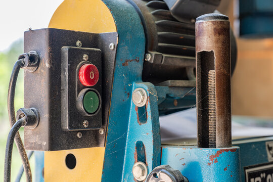 On and off buttons on a light blue woodworking machine - Powered by Adobe
