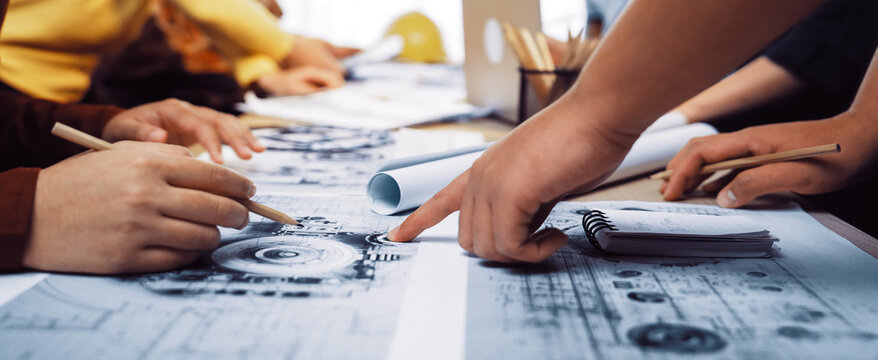 A dynamic scene in a design studio where creative minds collaborate on drawings and blueprints, engaging in discussions and sharing innovative ideas together. SACTR