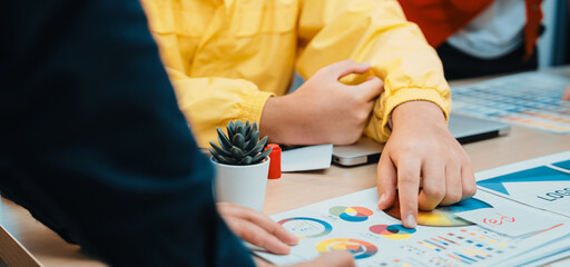 A vibrant office scene showcasing collaborative teamwork, with hands examining colorful charts and documents, highlighting data analysis and strategic planning. SACTR