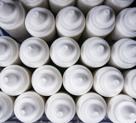 Close-up texture of grouped white plastic dropper containers for pharmaceuticals, cosmetics, or laboratory use. Top view