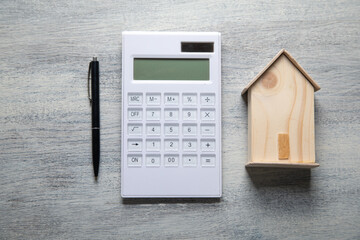 House model, calculator and pen on the table. Real estate