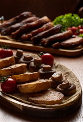 Fried potatoes with mushrooms and cherry tomatoes on a white background.